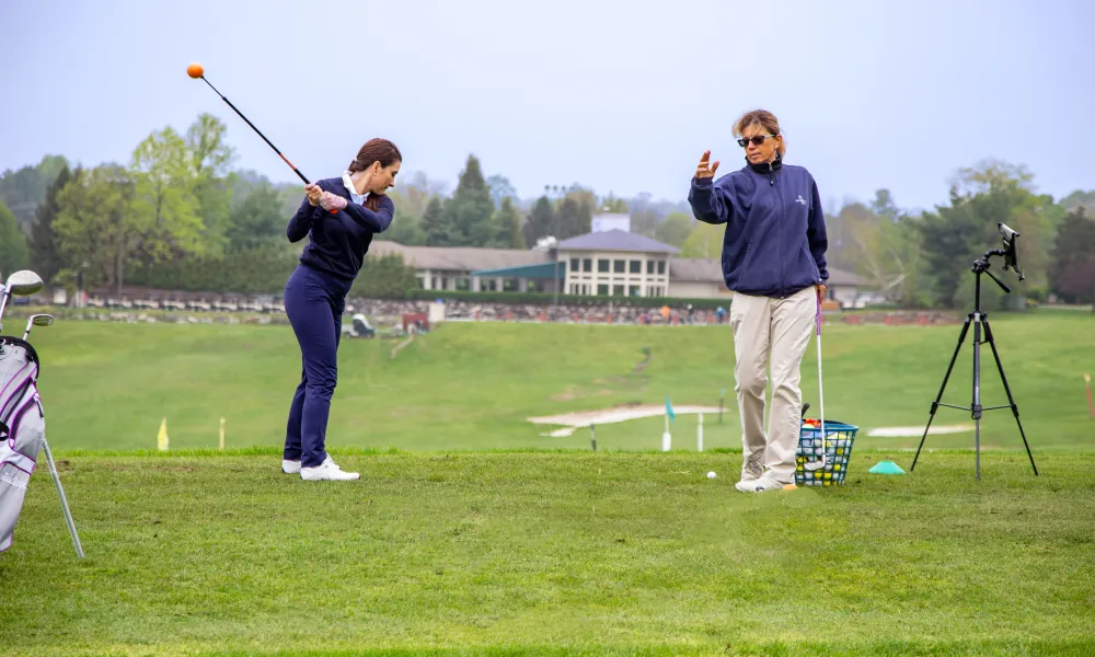 Girl learning to golf by instructor at Leadbetter Golf Academy