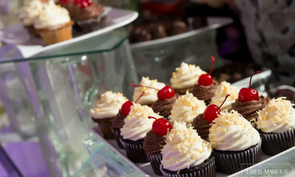 Vanilla and chocolate cupcakes with cherries on top