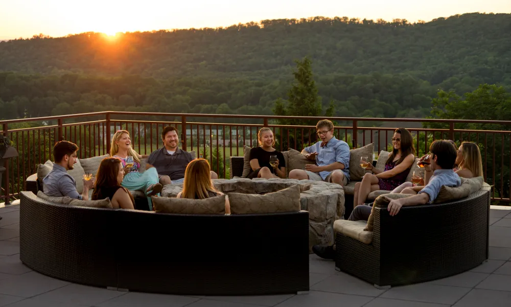 A corporate group enjoying drinks on the Fire + Water Terrace at sunset