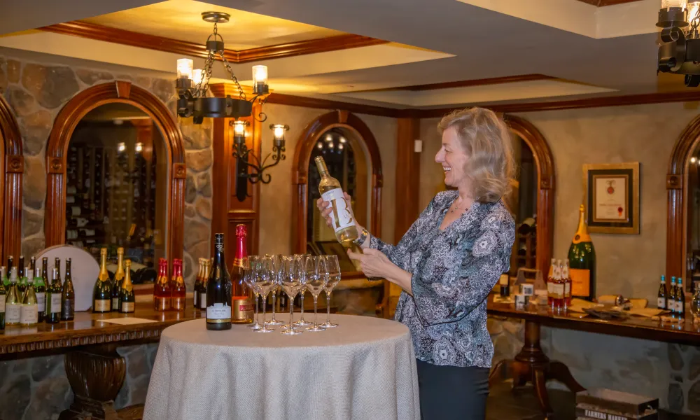 Susanne Wagner holding a bottle of wine in the wine cellar.