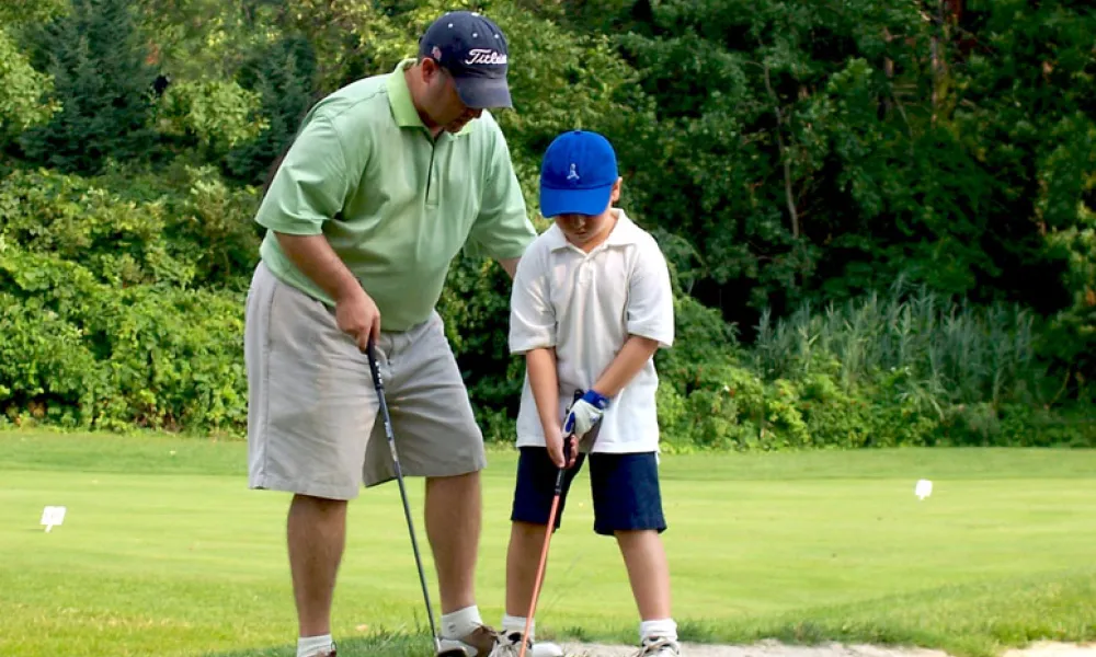 Father and son near a bunker at a golf course at Crystal Springs Resort