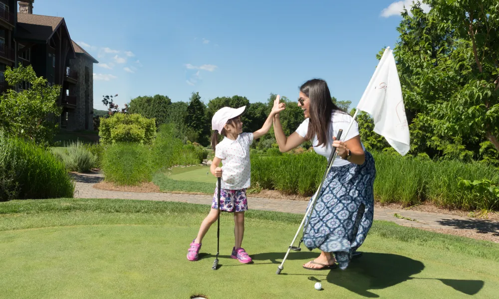 Mother and daughter at the natural grass putting course at Grand Cascades Lodge