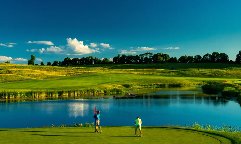 Two guys on the putting green of a golf course at Crystal Springs Resort