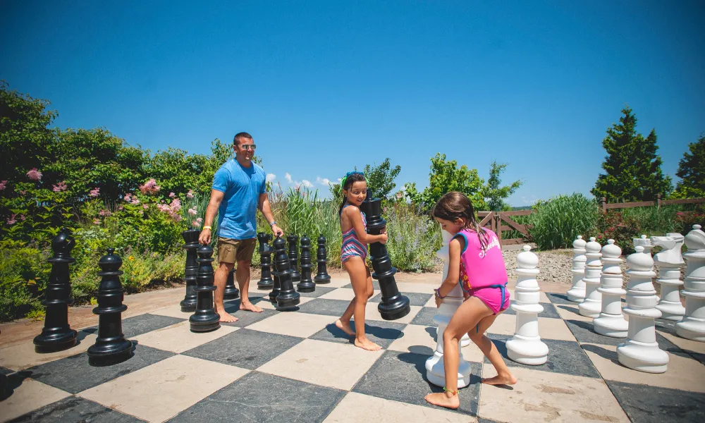 Young girls playing jumbo chess at Grand Cascades Lodge pool