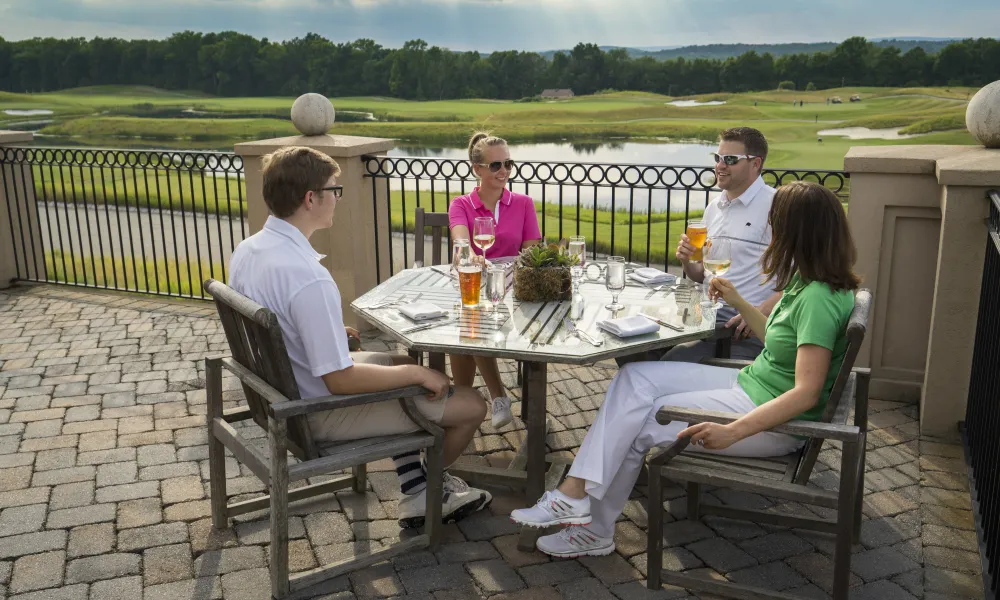 Two couples enjoying outdoor dining on the patio at Ballyowen Golf Club