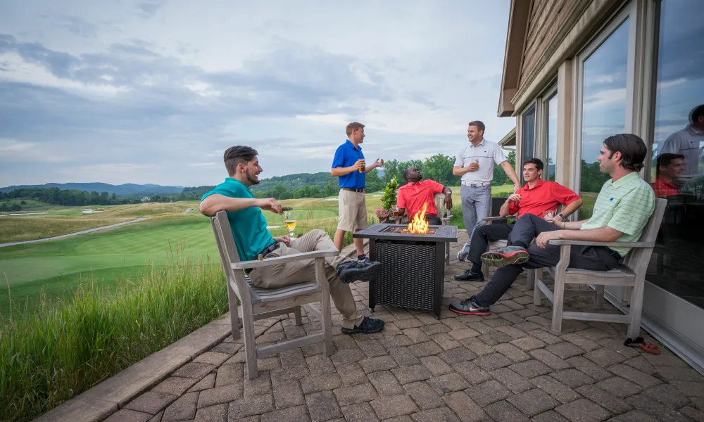 Group of guys enjoying drinks over a fire pit