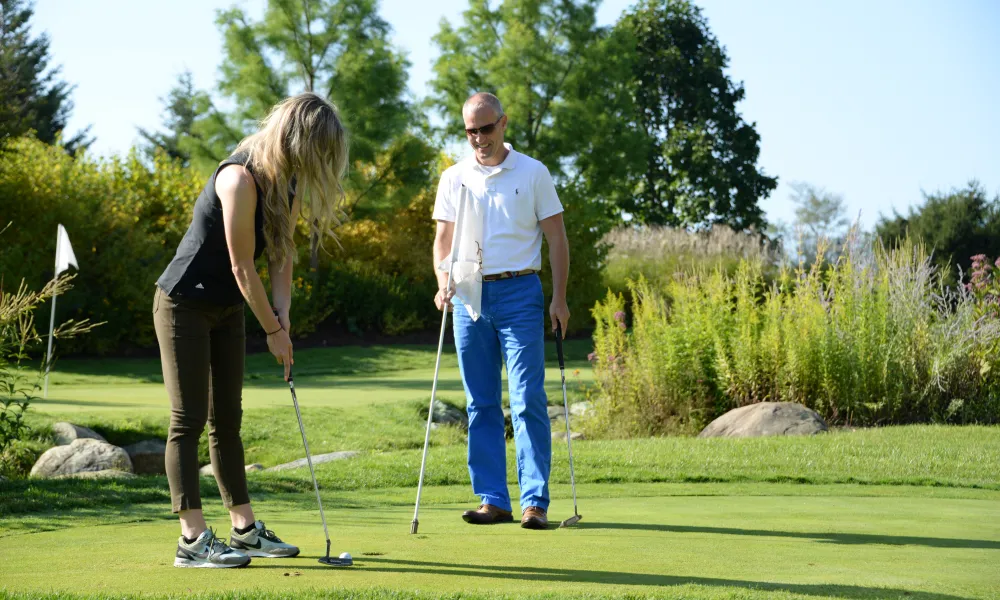 Couple playing on the putting green enjoying a relaxing getaway at a resort close to NYC