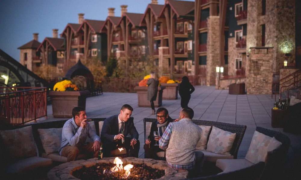 Corporate guys hanging out by a fire pit at Grand Cascades Lodge