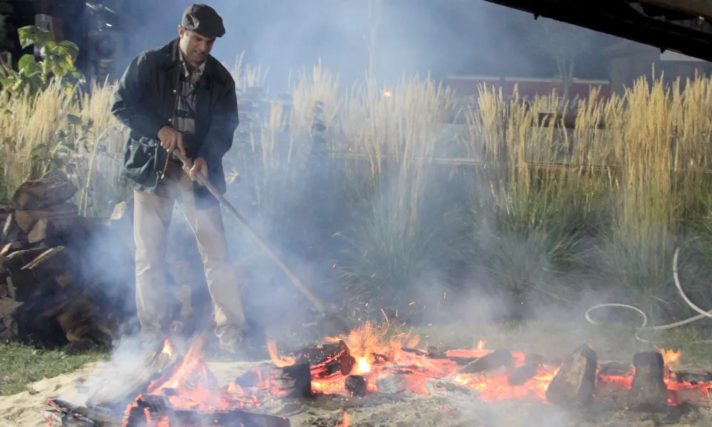 Robby Younes cooking on an open-fire at Mallman Event