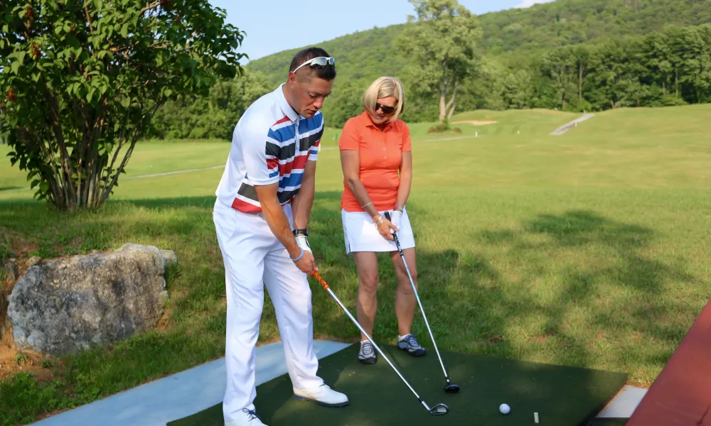 Woman taking golf lessons on the driving range