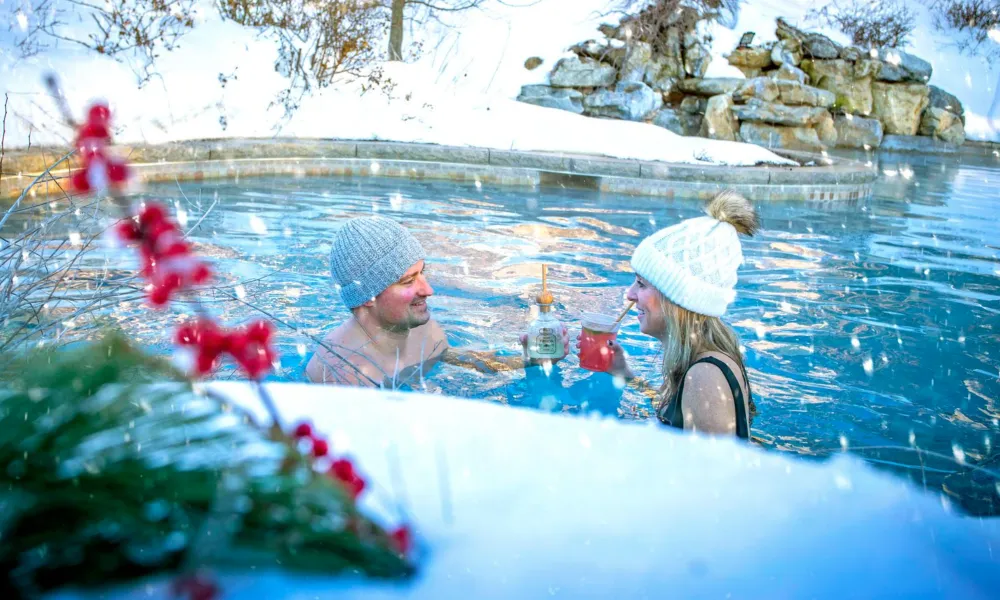 A couple enjoying drinks in an outdoor pool at Crystal Springs Resort