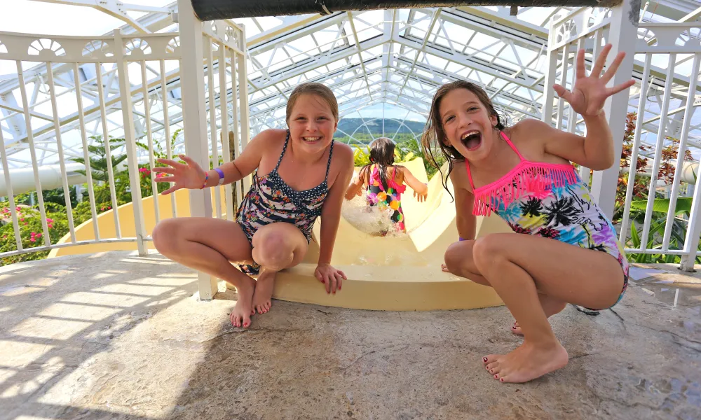 Two girls at top of Biosphere pool complex indoor slide.