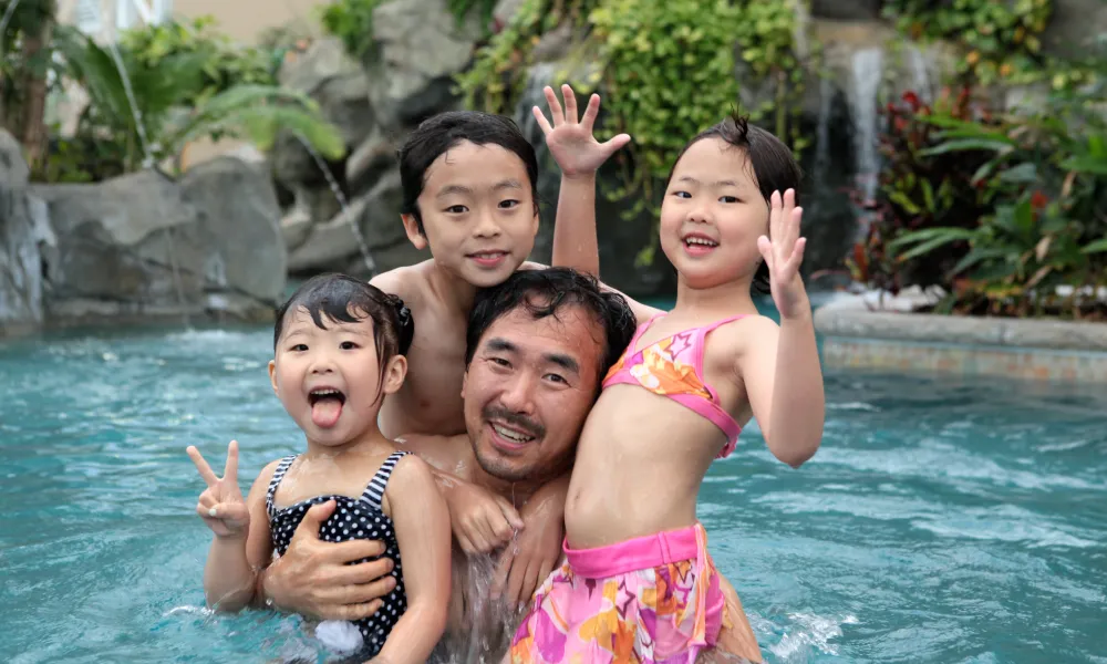 Three children and father in biosphere pool complex.