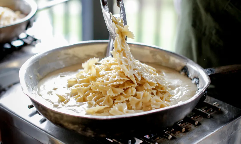 Chef cooking fresh Alfredo pasta 