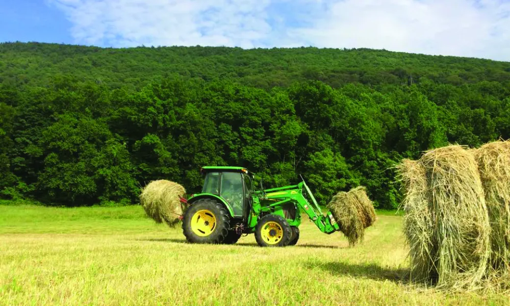 Tractor picking up hay