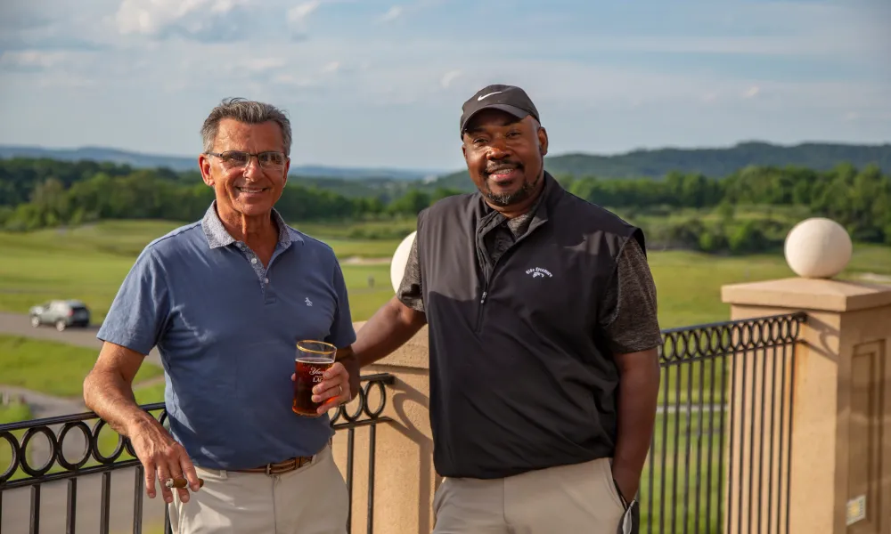 Two guys on the outdoor patio of a golf club at Crystal Springs Resort