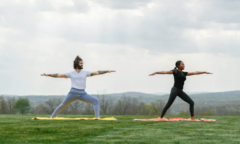 Couple doing warrior yoga pose