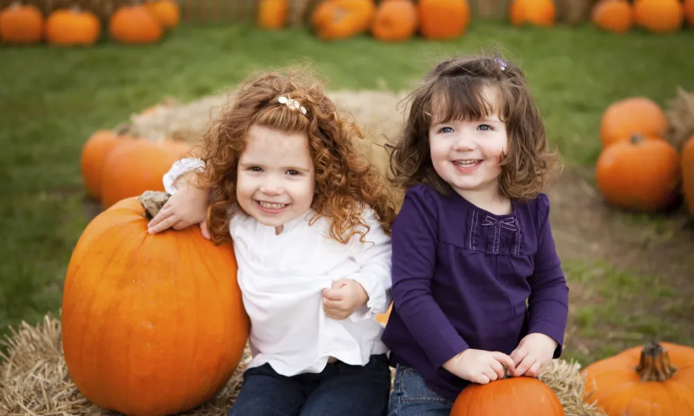 Young girls smiling in pumpkin patch