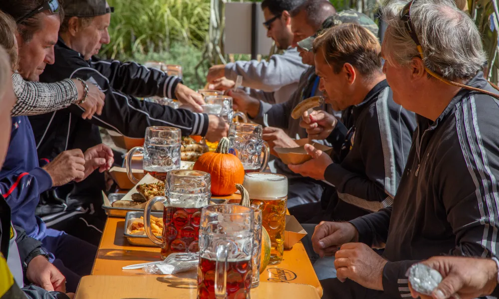 Group of people drinking steins of beer in Biergarten.