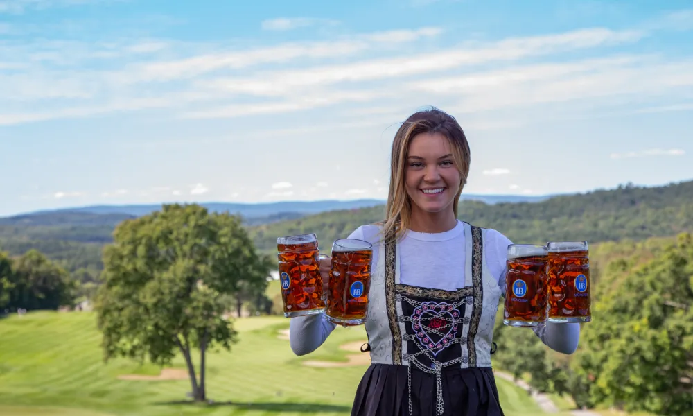 Biergarten bartender holding four steins of beer