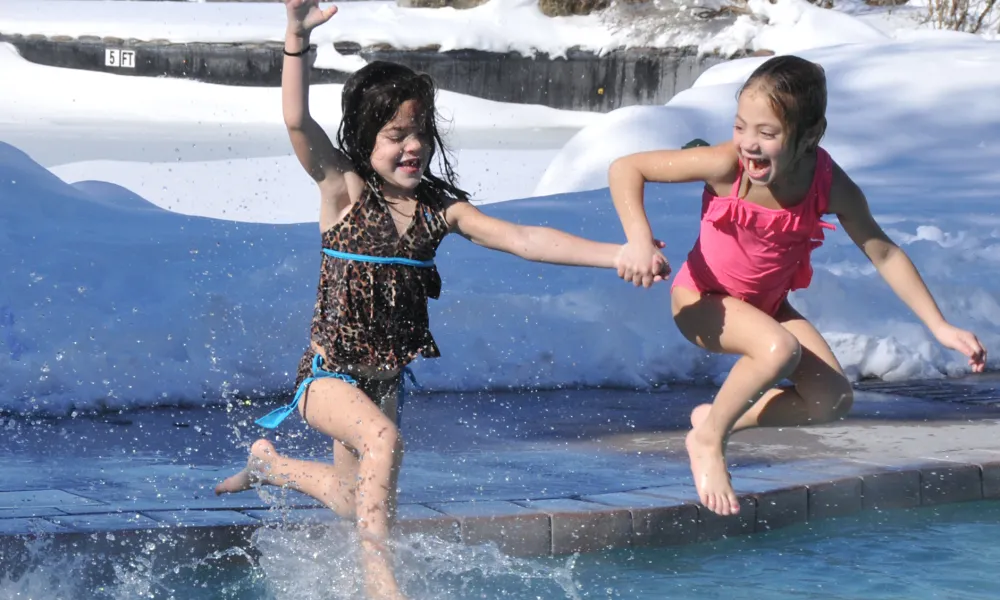 Young girls jumping into the snow pool at Minerals Hotel