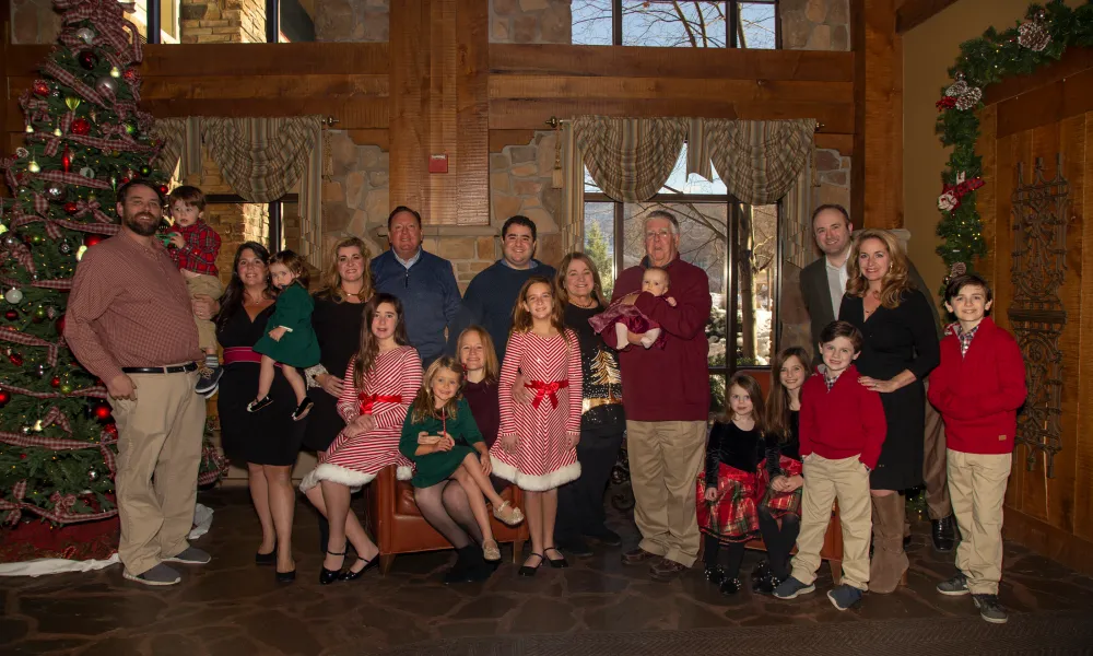 Family Christmas photo standing inside Grand Cascades Lodge