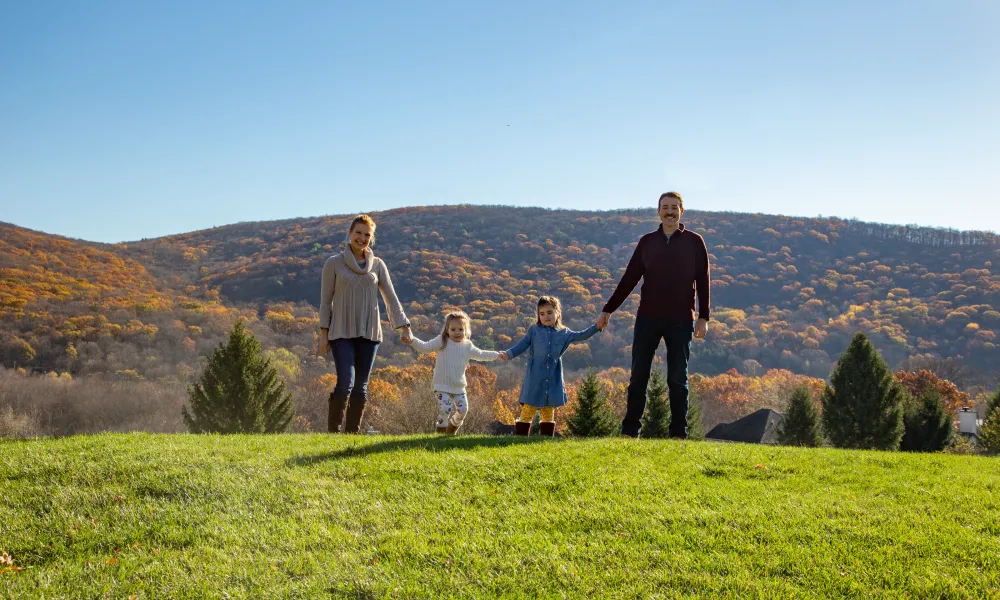 Family standing amongst the fall mountains