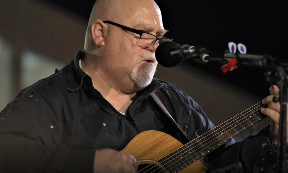 Man singing and playing guitar. 