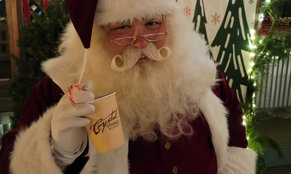 Santa holding cup of hot chocolate.