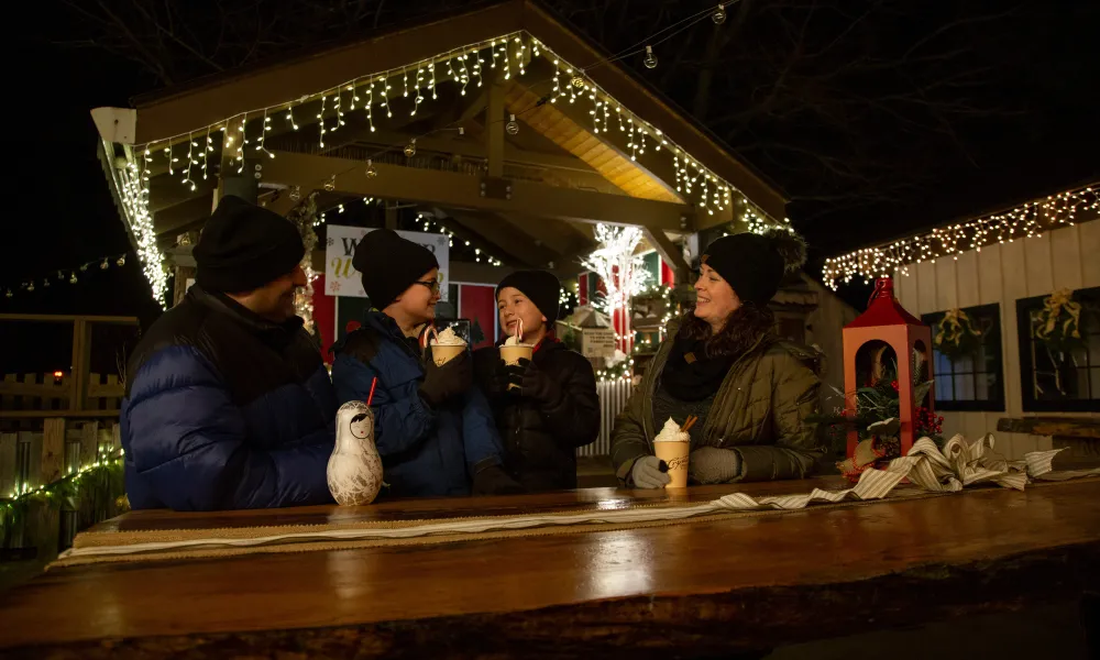 Family of 4 drinking festive drinks in Frosty's Cantina during vacation.