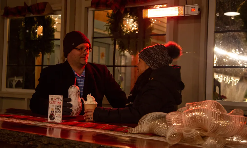 Couple sitting in Frosty's Cantina drinking festive beverages.