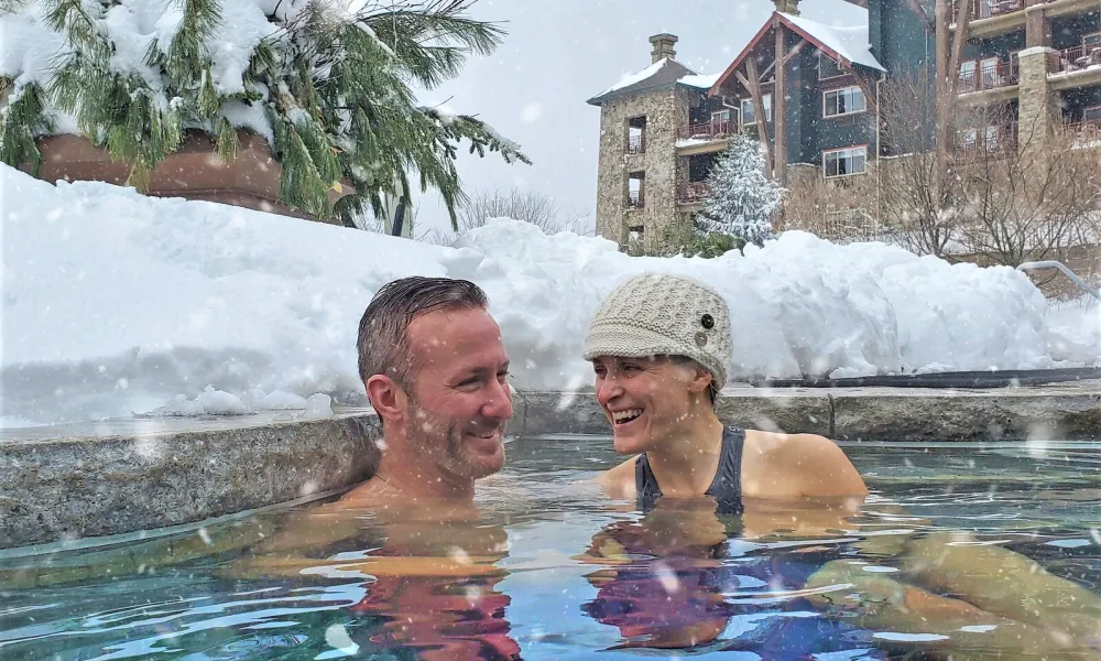 Couple enjoying the snow pool at Grand Cascades Lodge