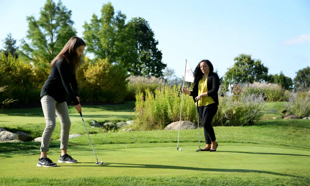 Girlfriends playing on the natural grass putting course at a resort close to NYC