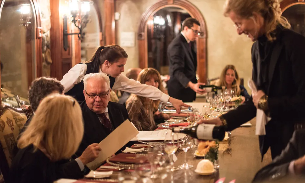 Group of people having dinner in the wine cellar.