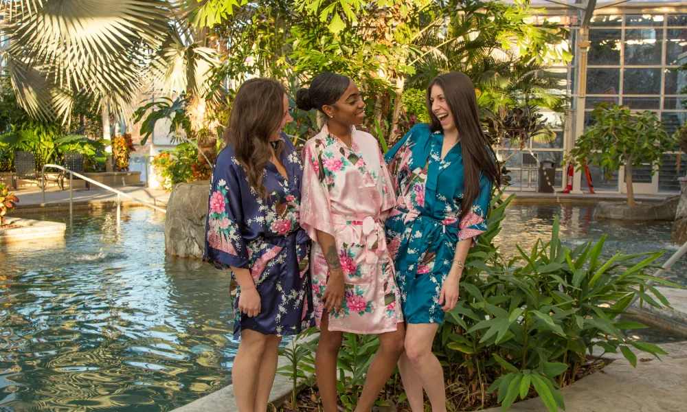 Women in floral robes standing by pool in Biosphere.