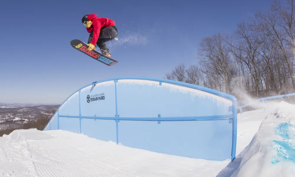 Person on snowboard jumping over lift.