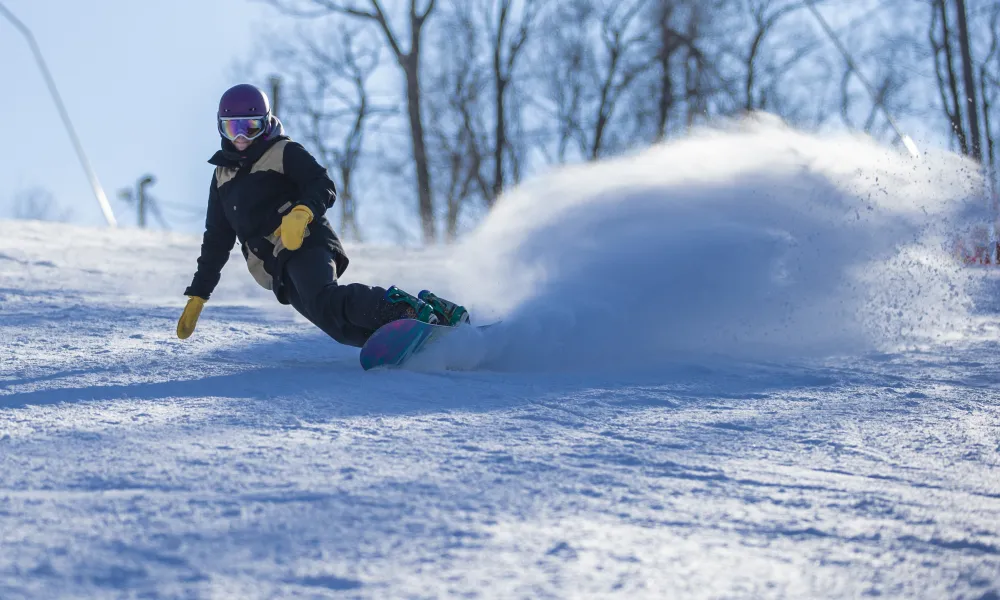 Person snowboarding down mountain.