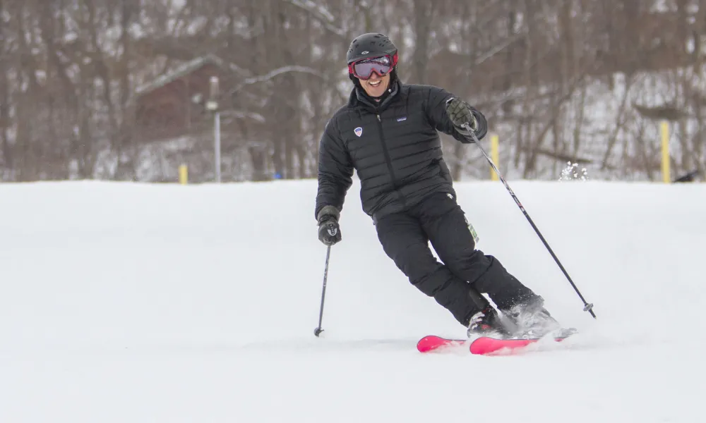 Person in black coat and pants skiing down mountain.