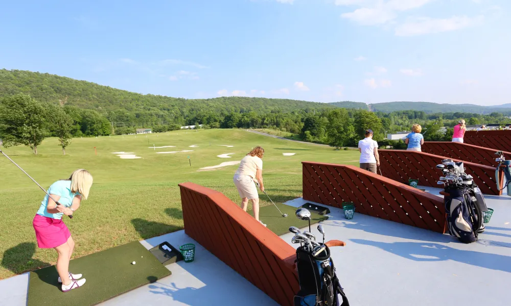 Women golfing at a driving range at Crystal Springs Resort