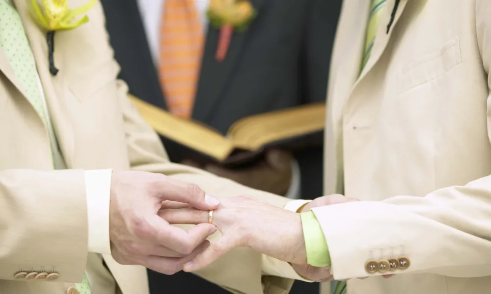 Groom putting on wedding ring