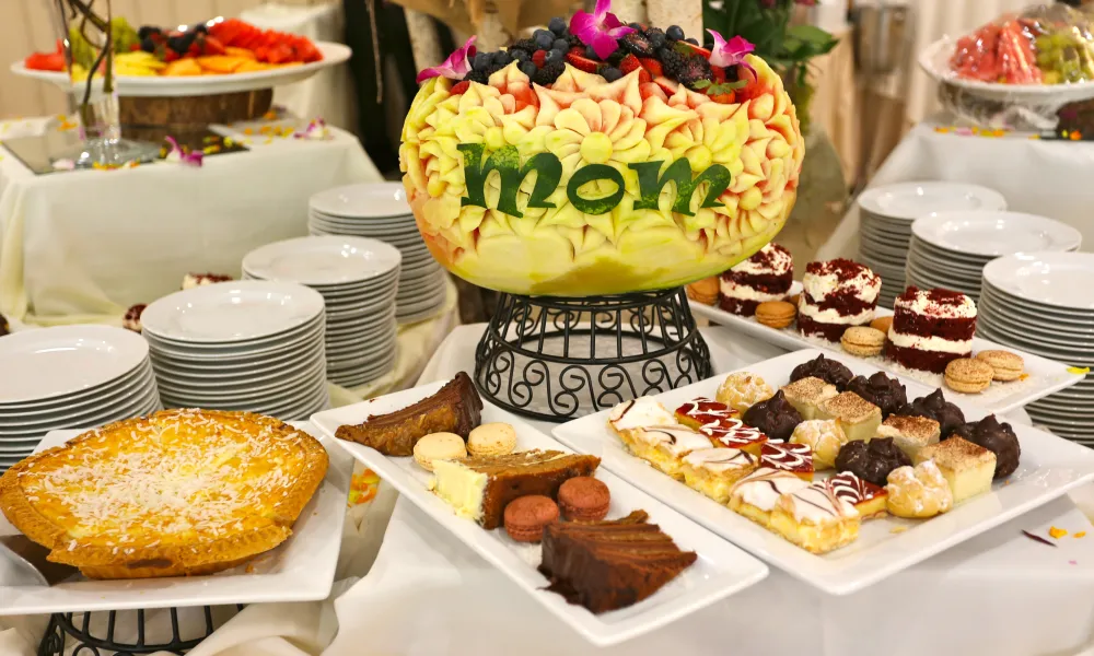 Melon carved to say &quot;mom&quot; at table of desserts