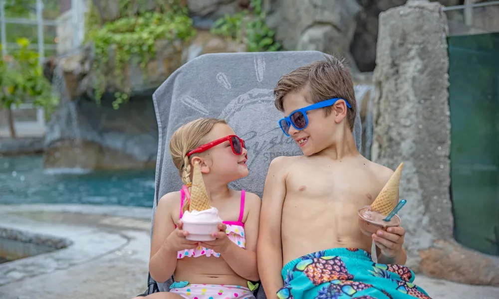 Bother and sister smiling with their ice cream cones by the pool at Crystal Springs Resort in NJ