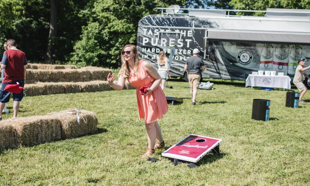 Women tossing bag playing corn hole at NJ Beer &amp; Food Festival