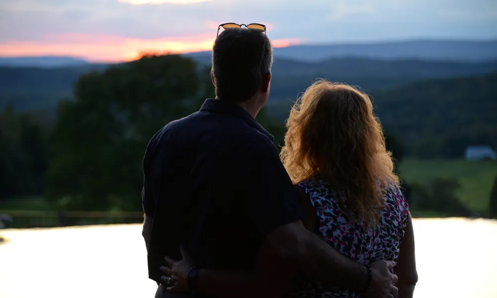 Couple looking at the sunset at vista 180 pool.