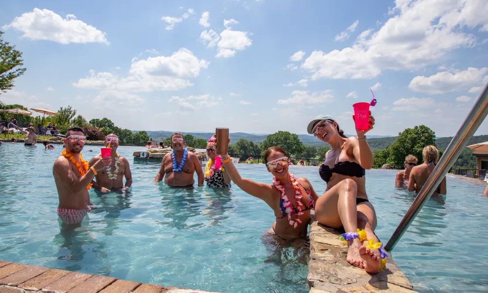 Group of people having luau at vista 180 pool party.