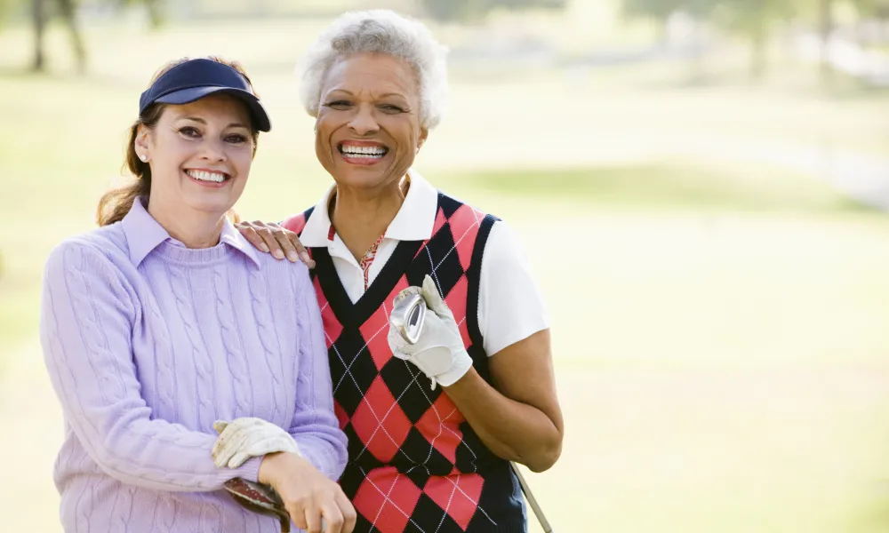 Two women standing on a golf course