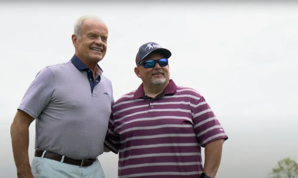 Kelsey Grammer standing with golfer.