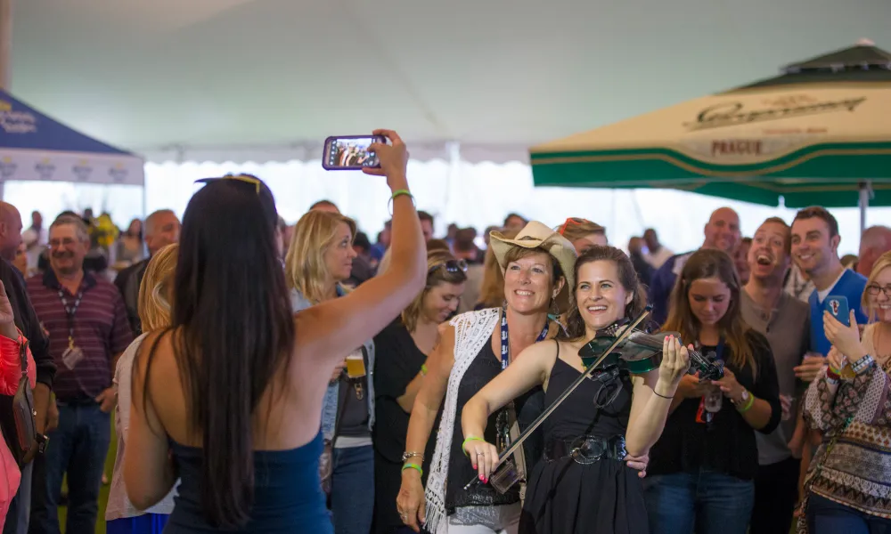 Someone taking flash photo of girl playing violin at NJ Beer &amp; Food Festival