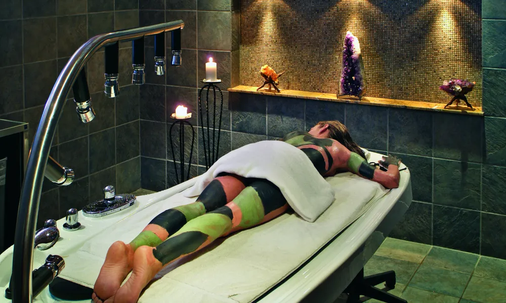 Woman receiving mud body treatment at Elements Spa.