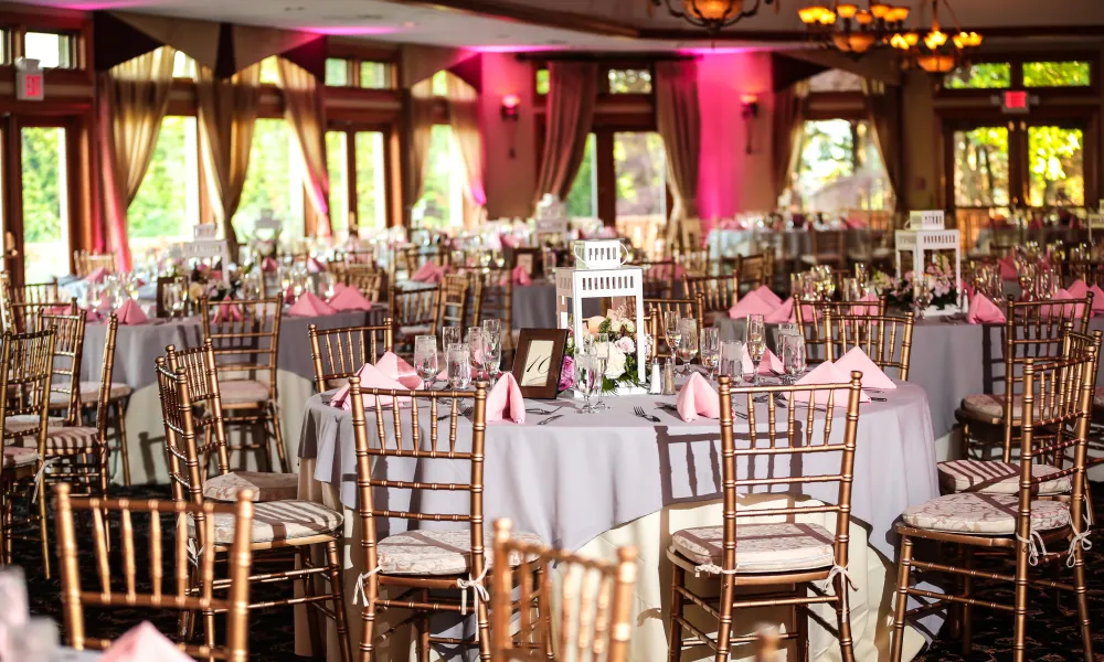 Wedding reception tables with pink uplighting at Black Bear Golf Club.